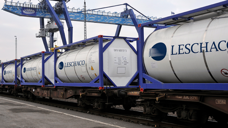  Tankcontainer: Viele Tankcontainer auf einem Güterzug. Die weißen Container sind mit einem großen Leschaco-Logo bedruckt. 
