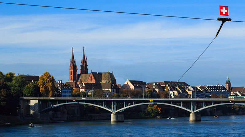Schweiz: Panoramabild von der Altstadt von Basel, Blick über den Rhein zu einer Brücke, schweizer Flagge oben rechts Schweiz: Panoramabild von der Altstadt von Basel, Blick über den Rhein zu einer Brücke, schweizer Flagge oben rechts