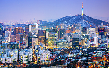 Südkorea: Nachtaufnahme von Seoul mit hell erleuchteten Hochhäusern. Im Hintergrund ist der Berg Namsan zu sehen 
