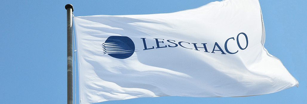  Blauer Himmel mit einer weißen Flagge im Vordergrund, auf der das Leschaco-Logo zu erkennen ist. 