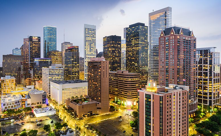 USA: Downtown Houston mit vielen erleuchteten Wolkenkratzern und Straßen am Abend