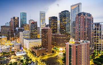 USA: Downtown Houston mit vielen erleuchteten Wolkenkratzern und Straßen am Abend